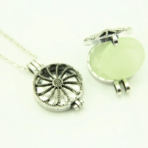 Détail du pendentif médaillon évidé en argent vintage ouvert avec une perle vert clair