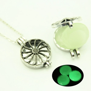 Détails du collier médaillon évidé montrant le symbole de paix et la perle lumineuse