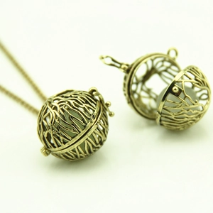 Macro shot of vintage hollow openable heart pendant showing internal metal ball detail