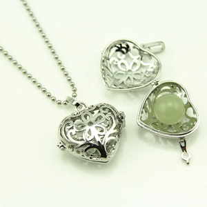 Collier pendentif cœur évidé vintage avec motifs floraux argentés et perle luminescente