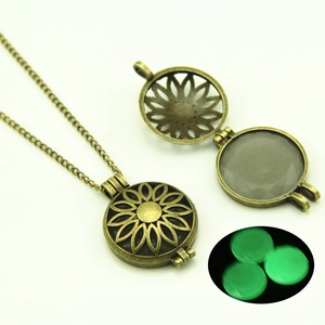 Detailed close-up of hollow sunflower bronze locket necklace with glowing green light