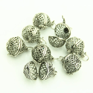Macro detail of antique silver hollow sphere pendants with intricate mesh and coin patterns