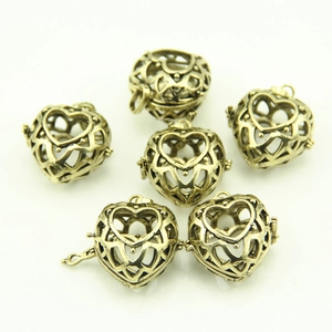 Detail view of hollow heart locket pendants with vintage floral patterns and hinges