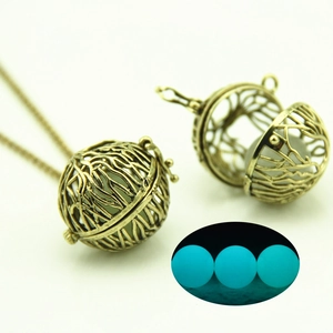 Detailed view of hollow heart necklace with glowing blue bead and vintage bronze chain