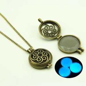 Detail of antique bronze filigree locket with glowing blue luminous stone bead