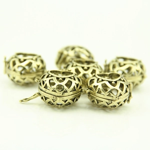 Detail view of hollow heart-shaped brass locket pendants for aromatherapy jewelry making