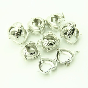 Set of seven silver heart-shaped locket pendants with hollow wing patterns on white base