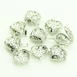 Detailed view of openable silver heart lockets with intricate hollow floral patterns