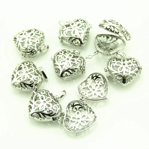 Detail of silver heart-shaped hollow lockets showing open and closed floral engraved patterns