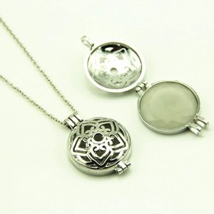Détail du collier à pendentif rond argenté ajouré montrant le motif floral filigrané