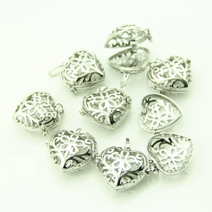Detailed macro view of openable heart-shaped silver locket pendants with floral carvings