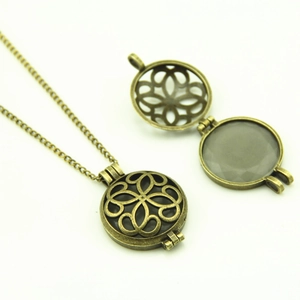 Detail view of a vintage bronze hollow clover locket necklace with inner moonstone
