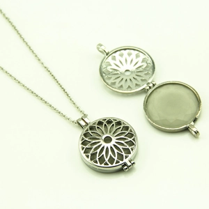 Vue détaillée du collier pendentif argenté évidé avec motif floral et design ouvrant