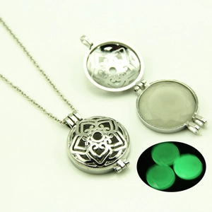 Vue détaillée d'un collier pendentif ajouré argenté avec une pierre lumineuse interne