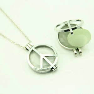 Collier symbole de paix argenté ajouré avec une pierre verte facettée à l'intérieur