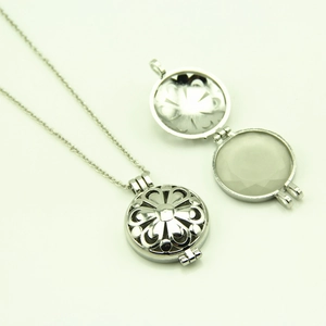Détail du collier pendentif ajouré argenté ouvrable avec motifs de fleurs et cœurs