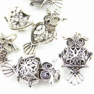 Macro detail of vintage owl locket pendant with intricate openwork and heart cavity