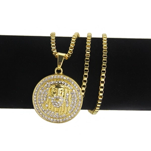 Collier avec pendentif tête de Jésus en or et zircons sur un support de bijoux noir