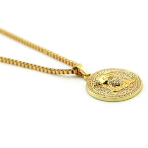 Détail du pendentif Méduse doré avec strass scintillants sur un collier à chaîne cubique