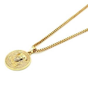 Gros plan détaillé d'un pendentif Jésus doré avec cristaux brillants sur chaîne box