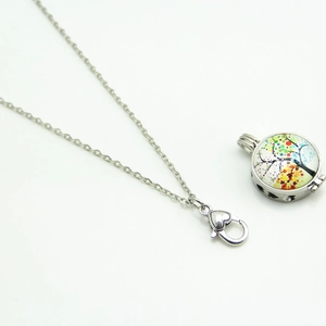 Detailed view of silver openable locket pendant with a colorful tree motif and heart clasp