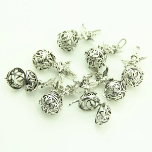 Detailed macro view of vintage silver hollow peace sign charms with angel wings