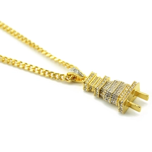 Detailed macro view of hip hop gold plug pendant with crystals on Cuban chain