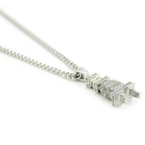 Macro view of iced out hip hop plug pendant necklace with silver tone micro pave zircons