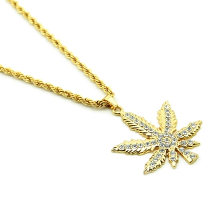 Dettaglio macro del ciondolo foglia d'acero hip hop dorato con micro-cristalli lucenti