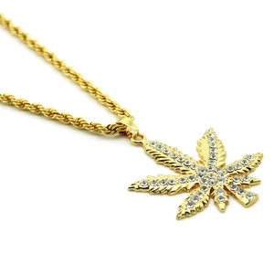 Dettaglio del ciondolo a foglia d'oro stile hip hop con strass e catena a corda