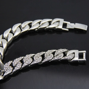 Primer plano de pulsera cubana plateada con eslabones pulidos y mitad con pavé de cristales