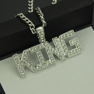 Close-up of silver King letter pendant with iced-out crystals and Cuban link chain
