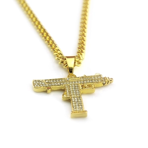 Detail of hip hop gold Uzi pendant with sparkling rhinestones on cuban link chain