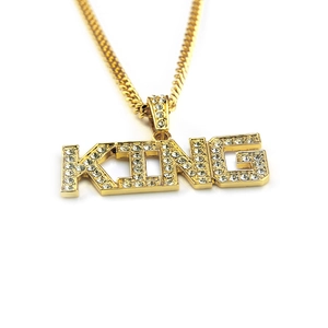 Close-up of gold KING letter pendant with sparkling crystals on Cuban link chain