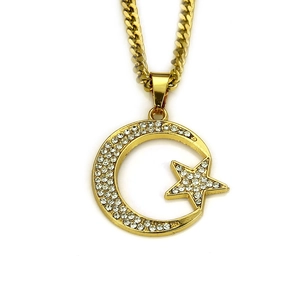 Détail du pendentif lune et étoile doré serti de strass sur une chaîne cubaine