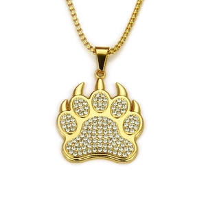 Gros plan du pendentif patte d'ours plaqué or serti de strass blancs brillants