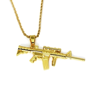 Gros plan détaillé du pendentif fusil AR-15 doré et de la chaîne torsadée pour homme