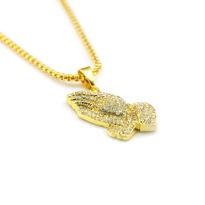 Détail du pendentif mains en prière style hip hop avec cristaux et placage or