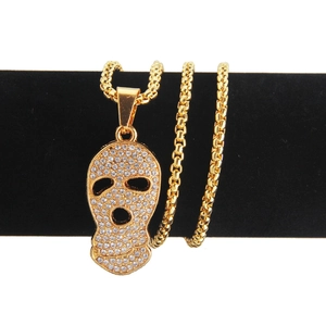 Pendentif tête de mort hip hop plaqué or avec diamants sur présentoir en velours noir