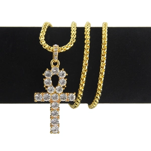 Gros plan d'un pendentif croix Ankh plaqué or avec strass brillants sur une chaîne box