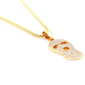 Détail du pendentif crâne hip hop doré avec strass blancs brillants et chaîne de boîte