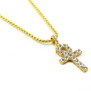 Vue détaillée du pendentif croix Ankh dorée sertie de strass avec sa chaîne à billes