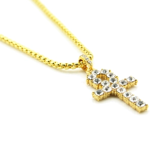 Détail du pendentif croix Ankh dorée sertie de strass brillants avec une chaîne à billes