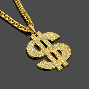 Détail d'un grand pendentif dollar plaqué or orné de strass brillants et chaîne cubaine