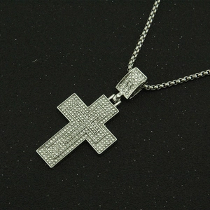 Macro view of iced out silver cross pendant necklace with sparkling micro pavé crystals