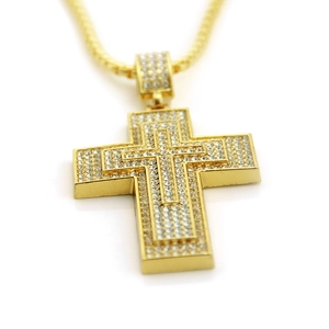 Close-up of gold iced-out Ankh cross pendant with tiered pave-set rhinestones