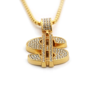 Close-up of gold-plated hip hop dollar sign pendant with white crystal pavé setting