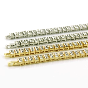 Close-up of double-row tennis bracelets with sparkling rhinestones in gold and silver finish