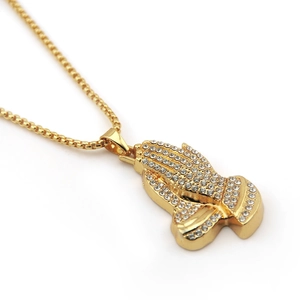 Gros plan du pendentif main de Hamsa doré avec strass étincelants sur chaîne box