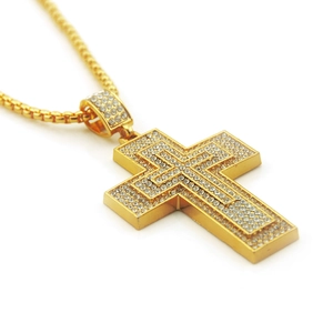 Detail of gold double-layered iced out cross pendant with sparkling crystals on box chain